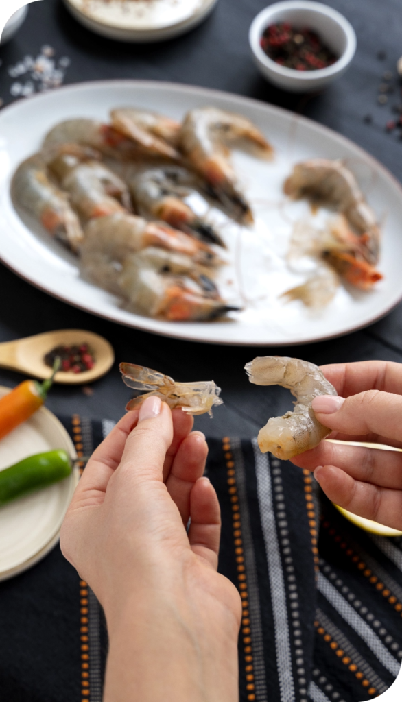 top view cook cleaning shrimp kitchen@2x